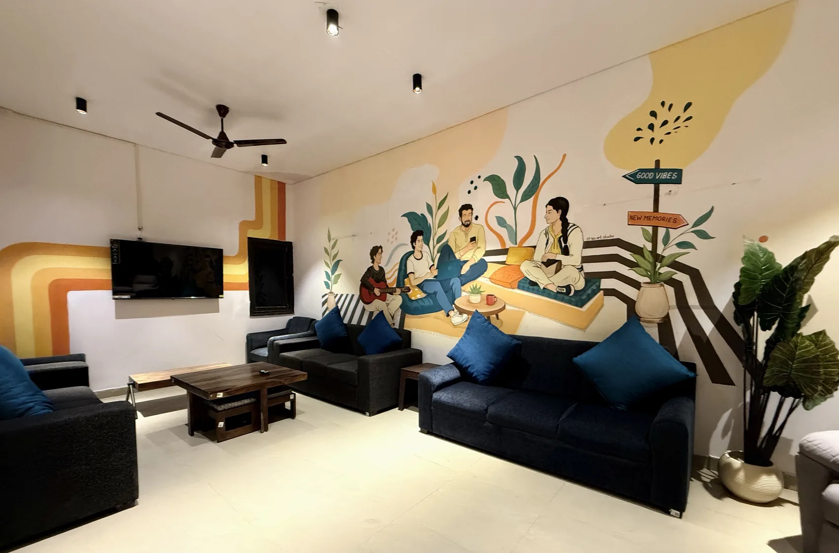 HOSHTEL99 Delhi common lounge with sofas and colourful wall art